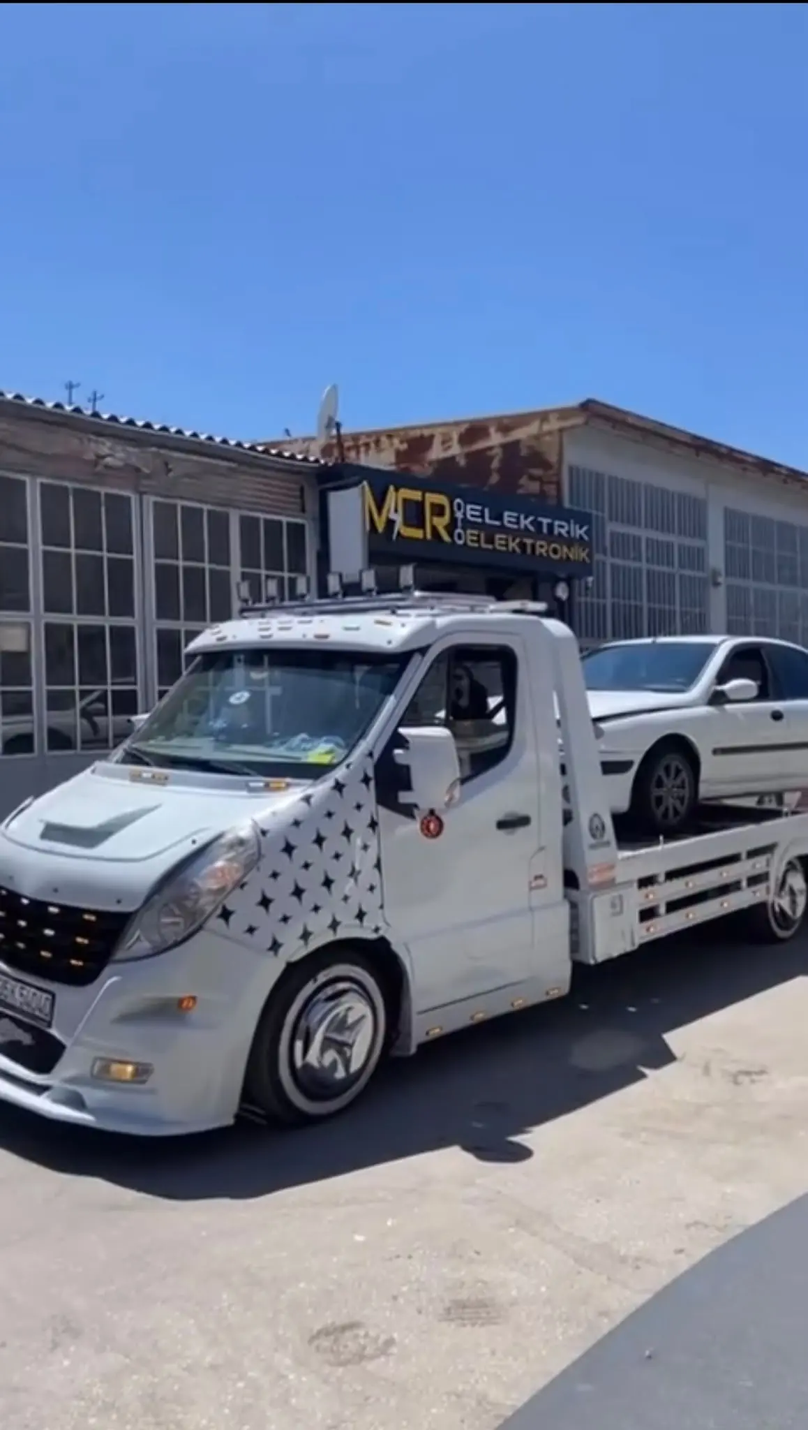 Platformlu çekici üzerinde taşınan gümüş renkli sedan otomobil